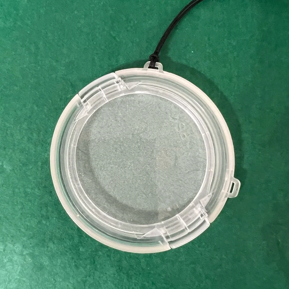 Plastic camera lens cover with string attachment